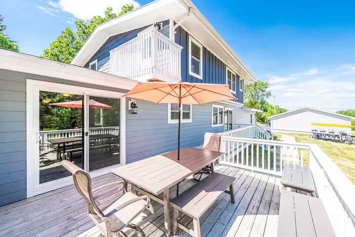 The back deck with umbrellas and picnic table — and the 9-person bike on the lawn